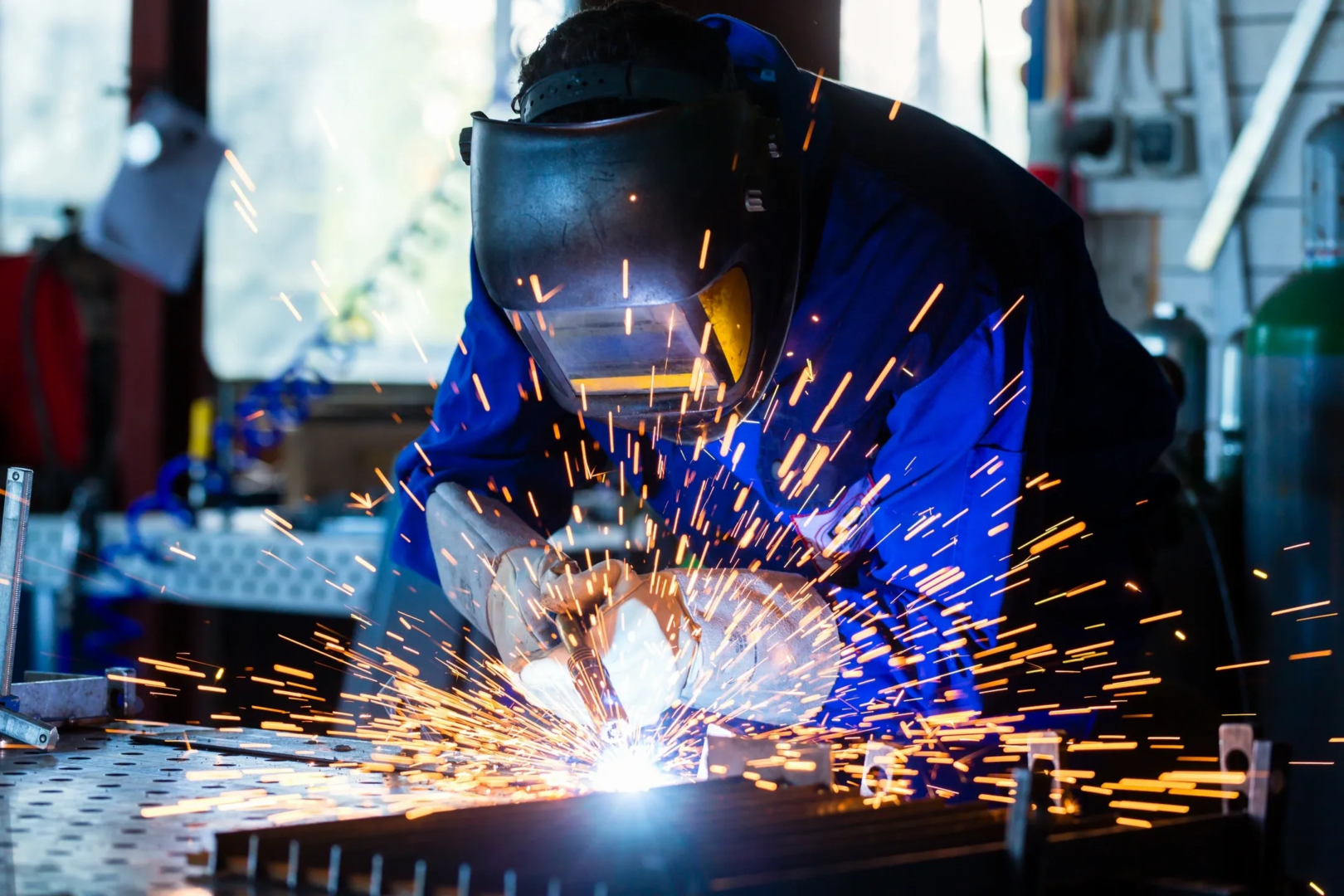 A person welding with sparks flying from the head.