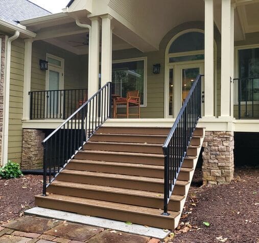 A front porch with steps and railings leading to the entrance.