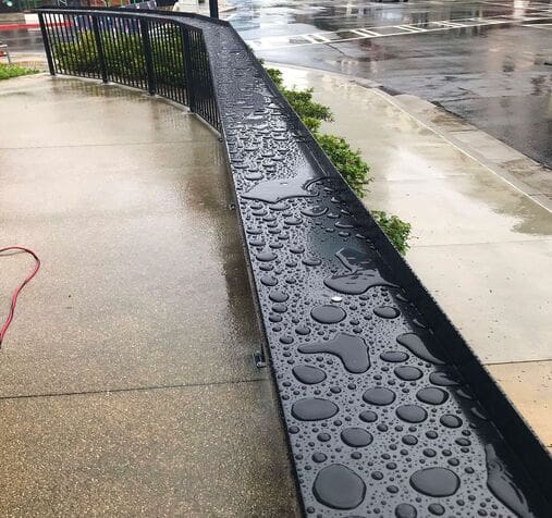A rain gutter with water drops on it